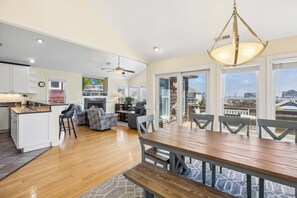 A spacious kitchen with a dining area, a fireplace, and large windows offering a view.