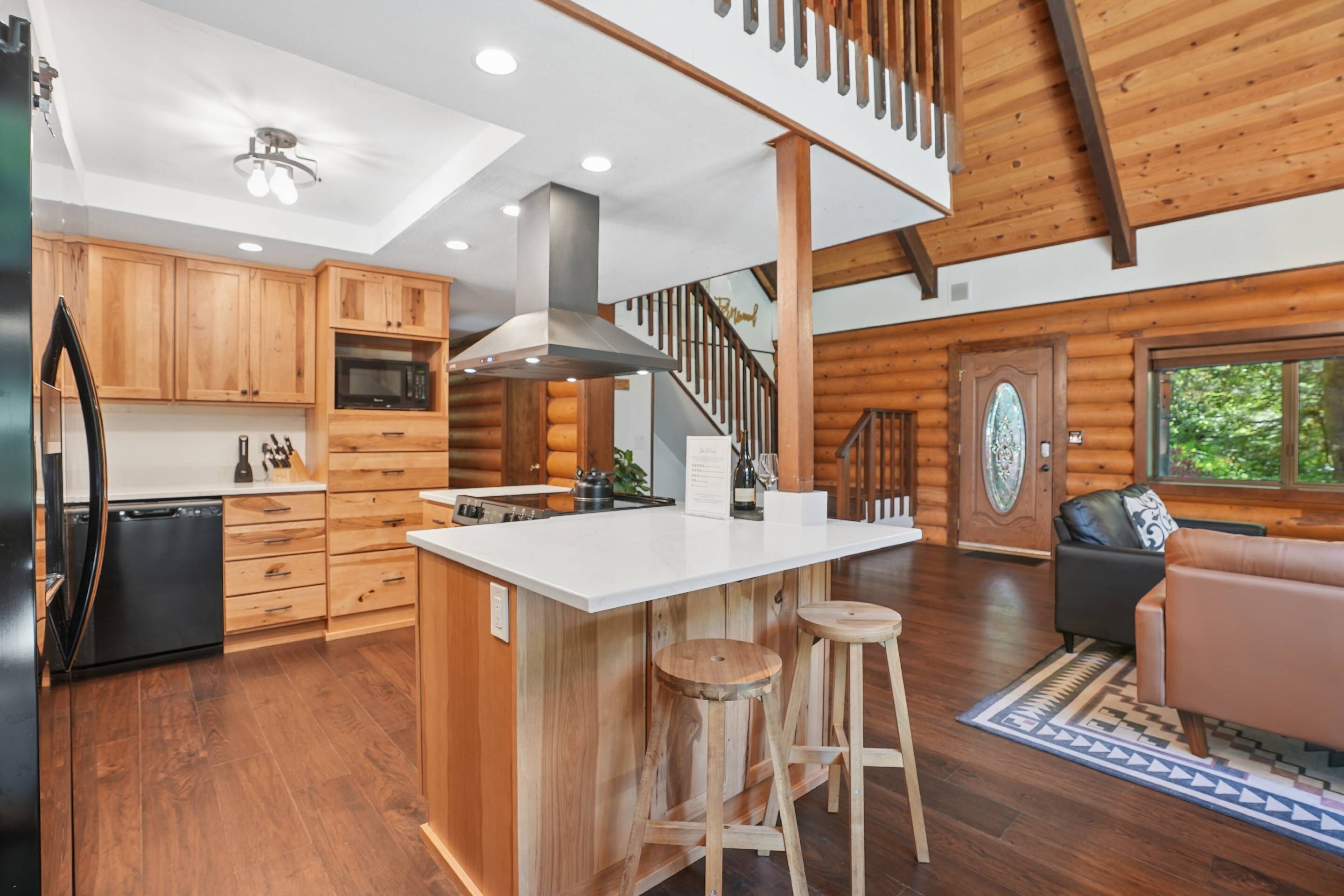 L’intérieur d’une cabane en rondins comprend une cuisine, un coin repas et un escalier.