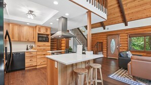 A log cabin interior with a kitchen, dining area, and a staircase. - Awesome Log Cabin and Guest Home on Two Acres, Pet Friendly, Hot Tub, Patio,15 Miles to Mt. Hood (Brightwood)