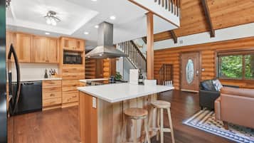 L’intérieur d’une cabane en rondins comprend une cuisine, un coin repas et un escalier.
