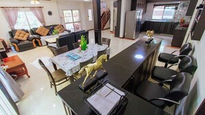 Un espacio habitable amplio con una mesa de comedor, sofá y una cocina al fondo.