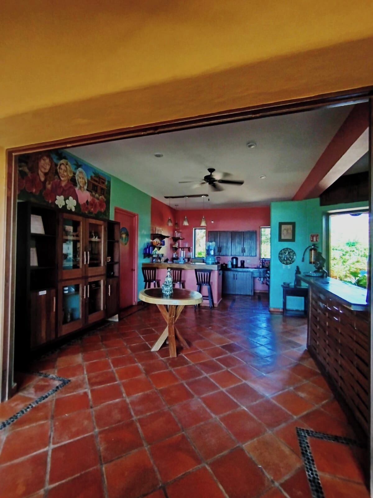 A spacious kitchen with a dining area, a ceiling fan, and a tiled floor.