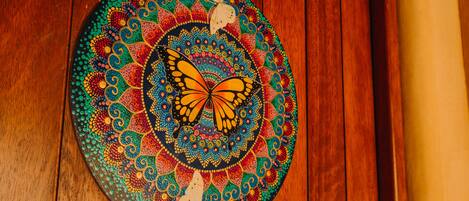 A circular, colorful artwork with a butterfly design on a wooden surface.