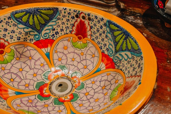Un tazón de cerámica decorativo con intrincados diseños florales y un orificio central.