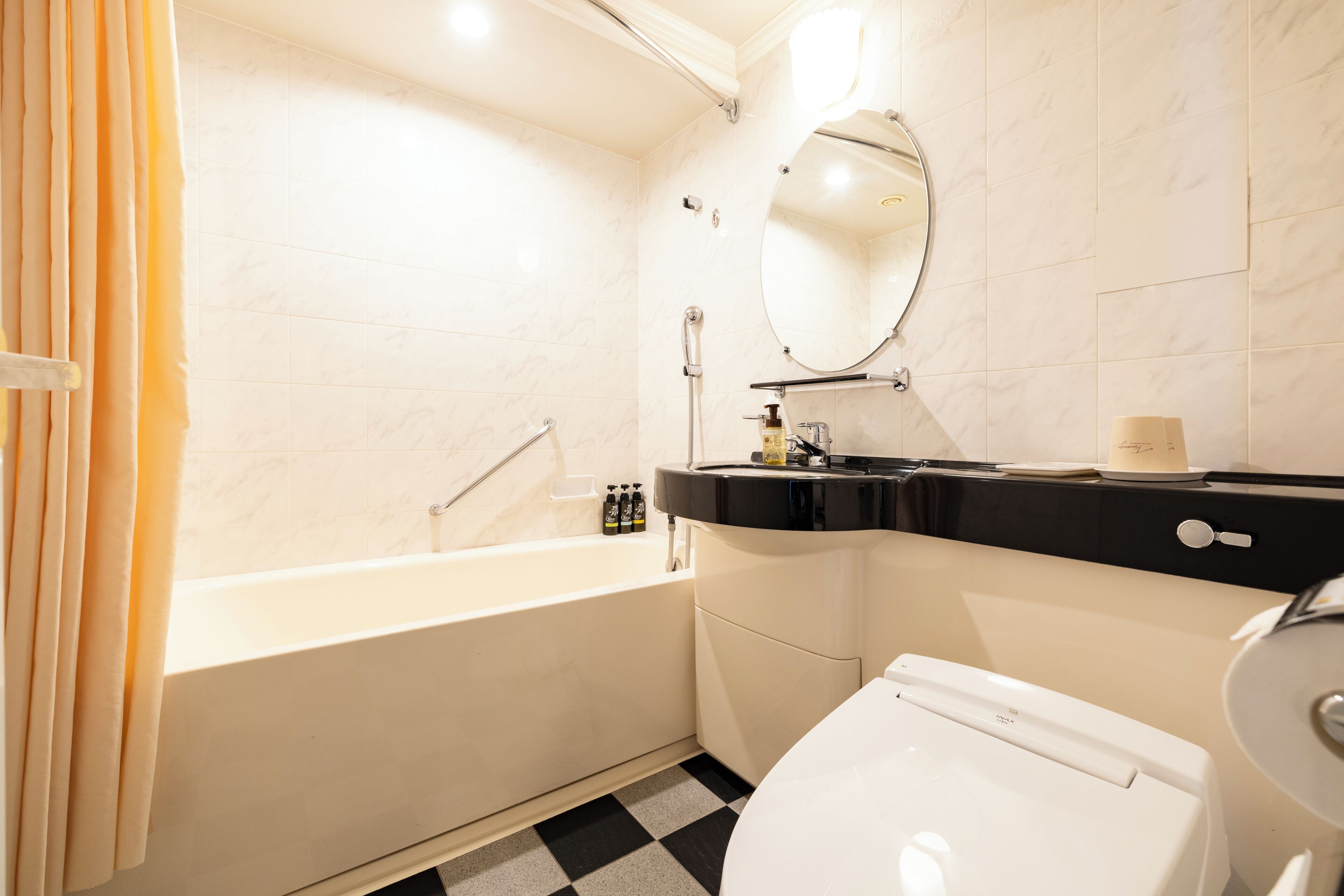 A bathroom with a bathtub, a toilet, a sink, and a mirror.