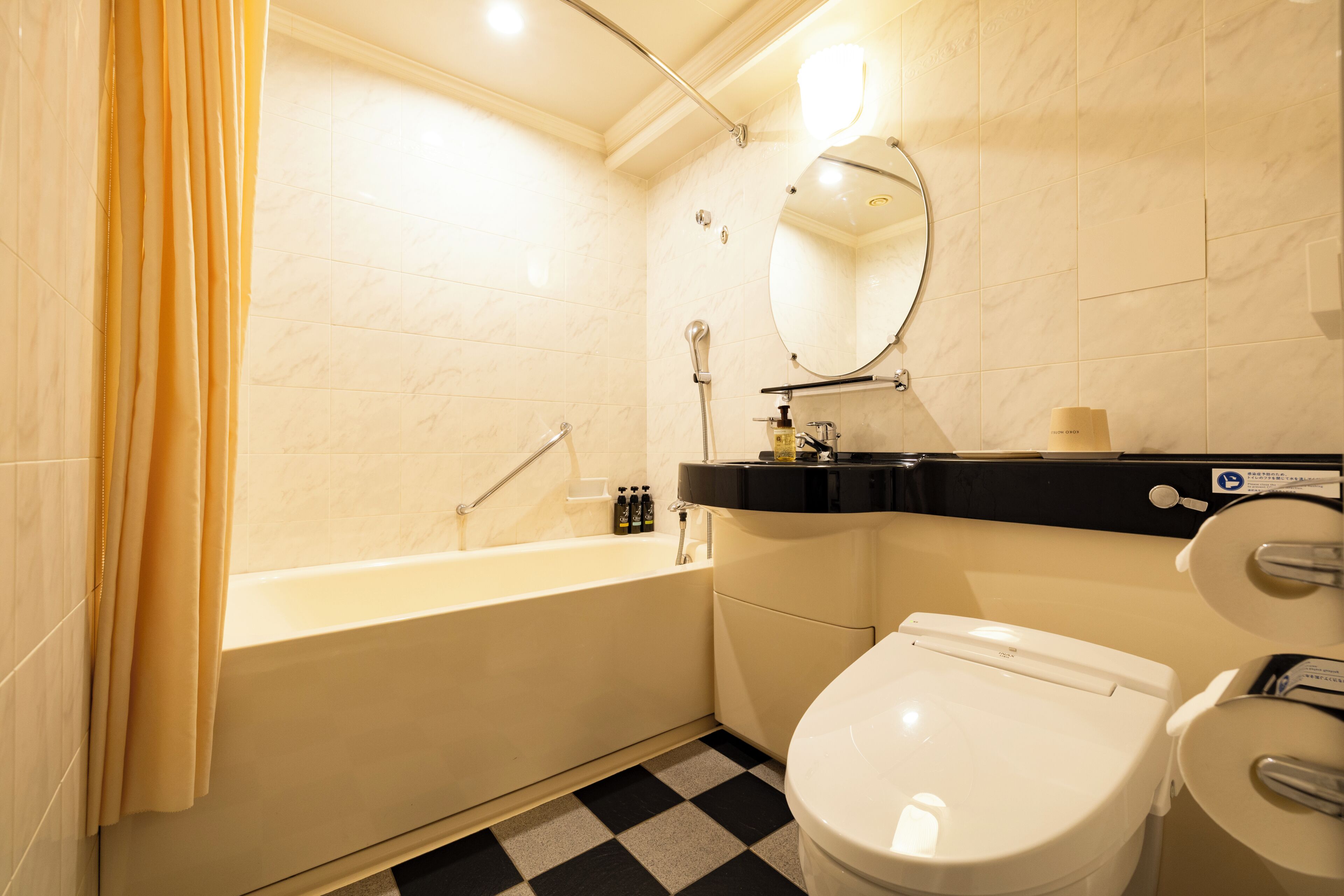 A bathroom with a bathtub, toilet, and a mirror.