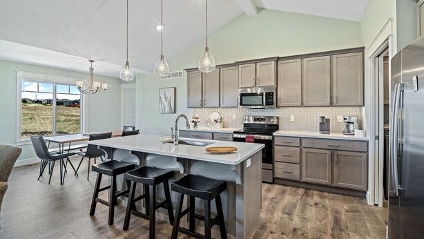 A modern kitchen with a large island, bar stools, stainless steel appliances, and a view of the outdoors. - New Home in west Manhattan,  Family Friendly and close to KSU! (Manhattan)