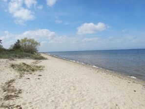 A sandy beach with a clear sky and calm sea.