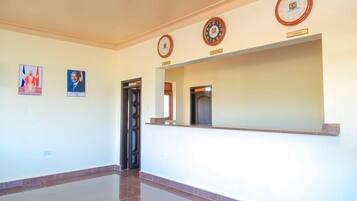 Un área de recepción con mostrador, dos relojes y cuadros en la pared.