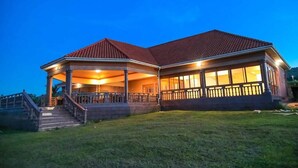 A two-story building with a covered porch and a staircase leading to the entrance. - Fancy Resort Beach Hotel (Jinja)