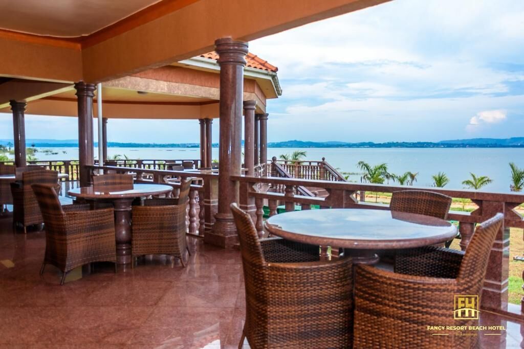 A covered outdoor seating area with wicker furniture and a view of the sea.