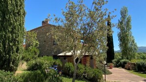 A stone building with a garden, a small structure, and a clear sky. - Libeccio by Interhome (Marina di Bibbona)