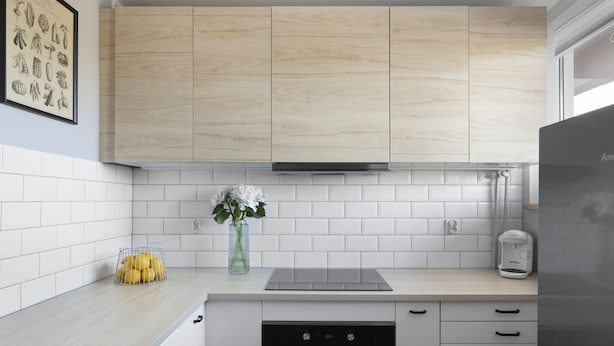 A modern kitchen with light wood cabinets, a white tiled backsplash, a built-in oven, and a coffee maker on the counter. - Elite Apartments Przymorze (Gdansk)