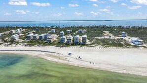 A coastal resort with beachfront properties, a sandy beach, and a clear view of the ocean. - The Blue Pearl- Gulf view home, Short stroll to beach, Community pool, Sleeps 10 (Port St. Joe)