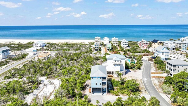 A coastal residential area with beachfront properties, roads, and sparse vegetation. - The Blue Pearl- Gulf view home, Short stroll to beach, Community pool, Sleeps 10 (Port St. Joe)