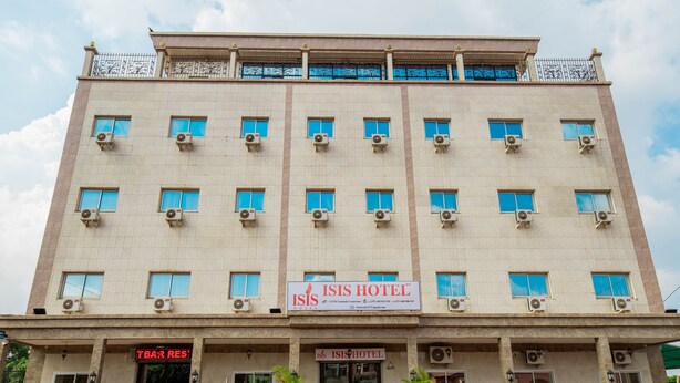 Un edificio de varios pisos con un cartel que dice ISIS Hotel y un bar llamado TBARES.