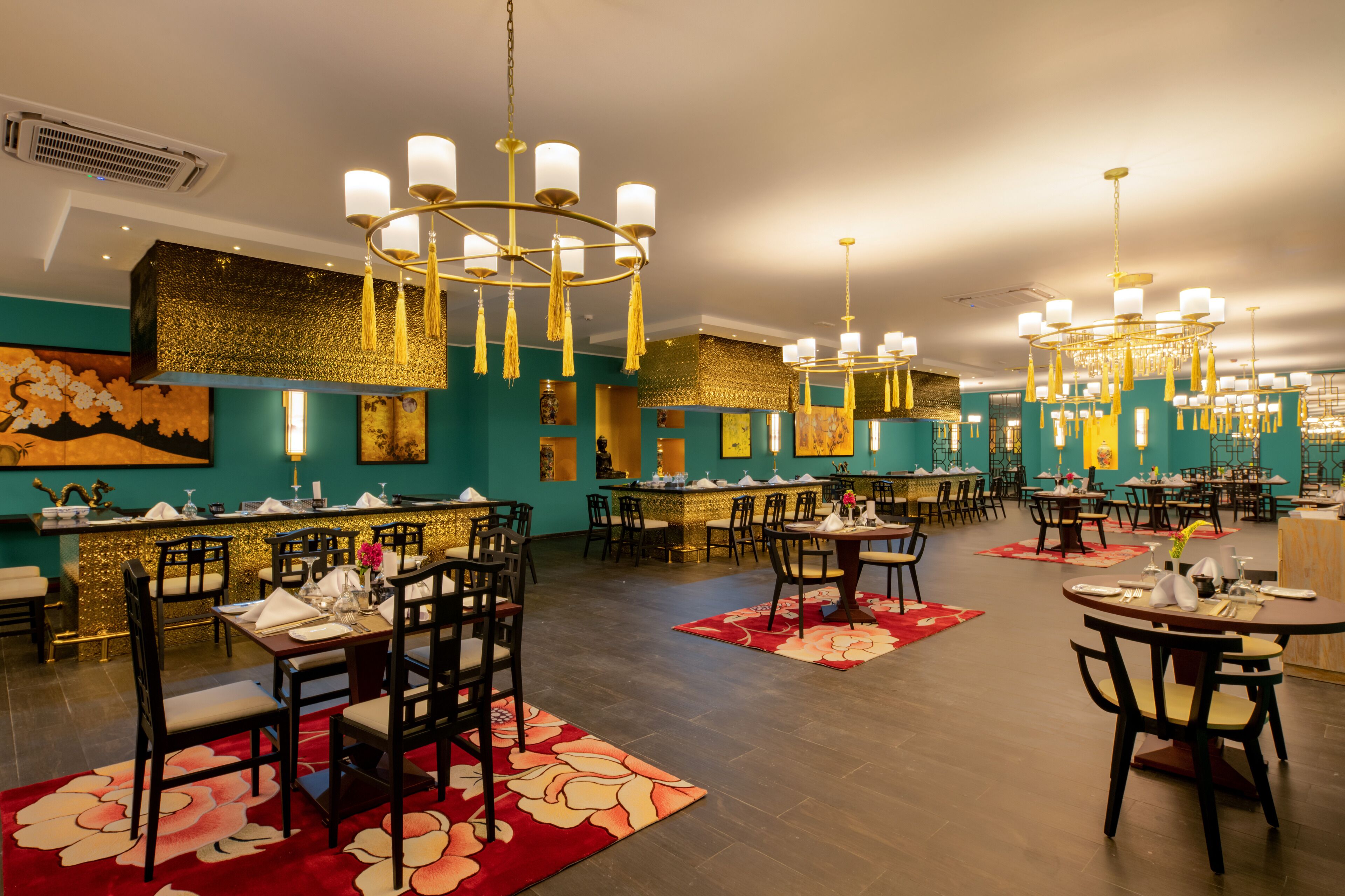 Un restaurante espacioso con varias zonas de comedor, cada una con mesas y sillas.