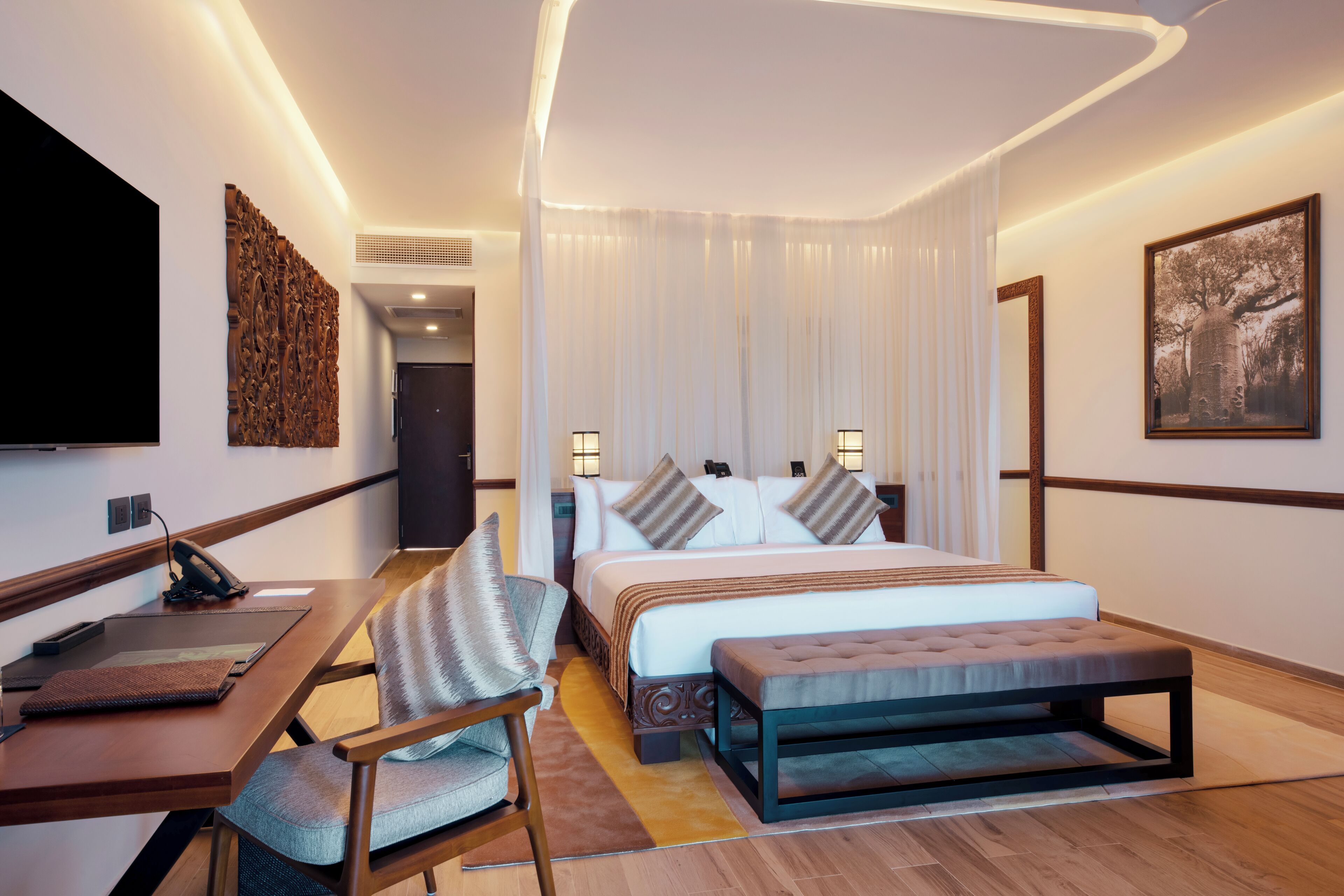 Een moderne hotelkamer met een groot bed, een bureau en een stoel.