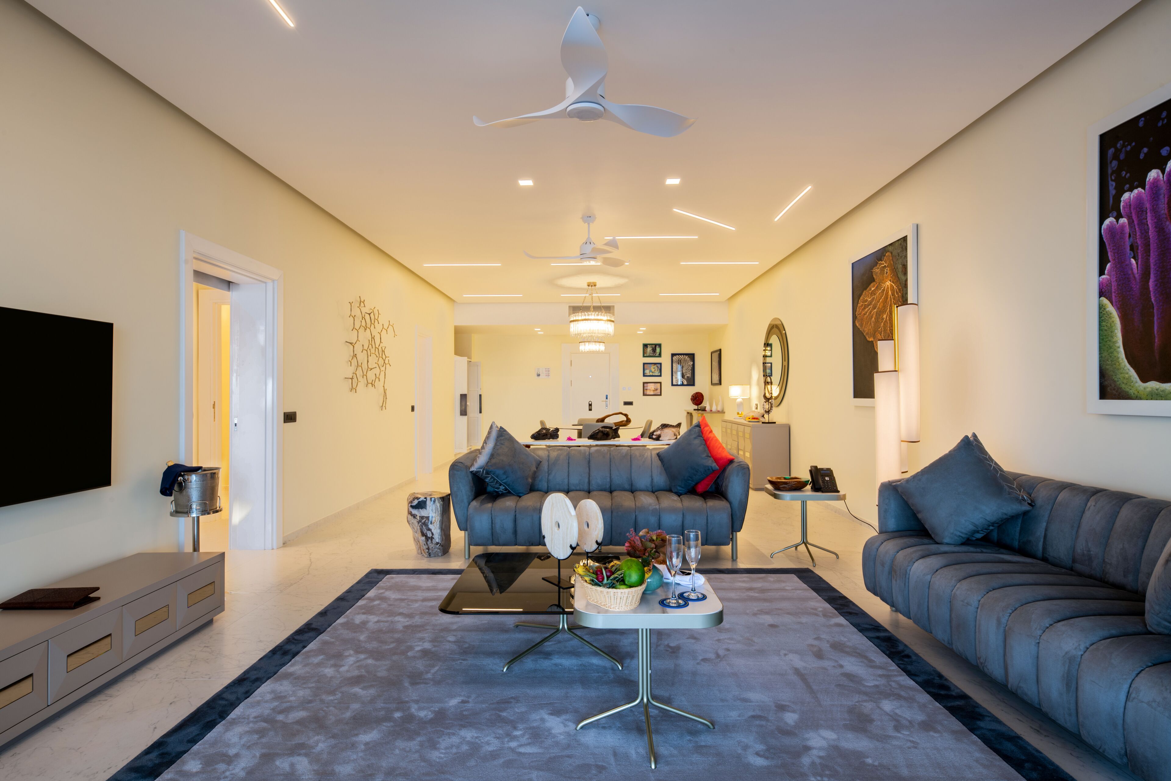 A modern living room with a grey sofa, a coffee table, and a TV on a stand.