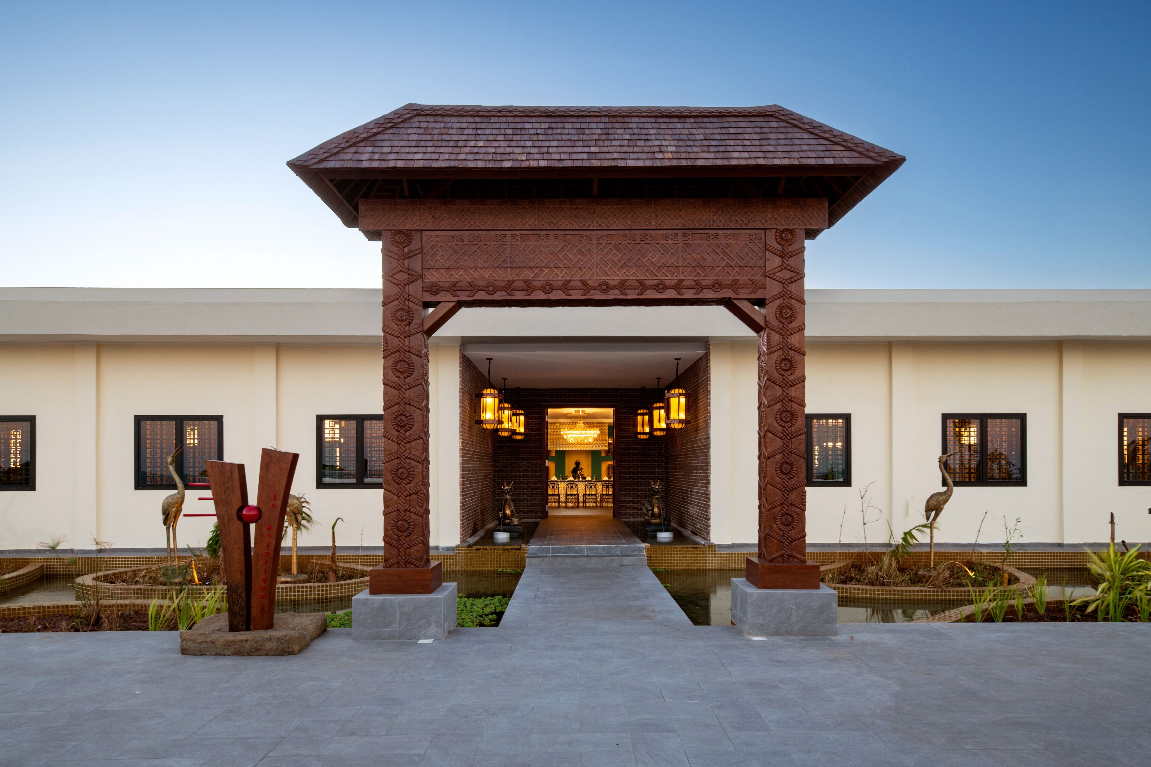 A building entrance with a covered walkway, decorative columns, and a reception area.