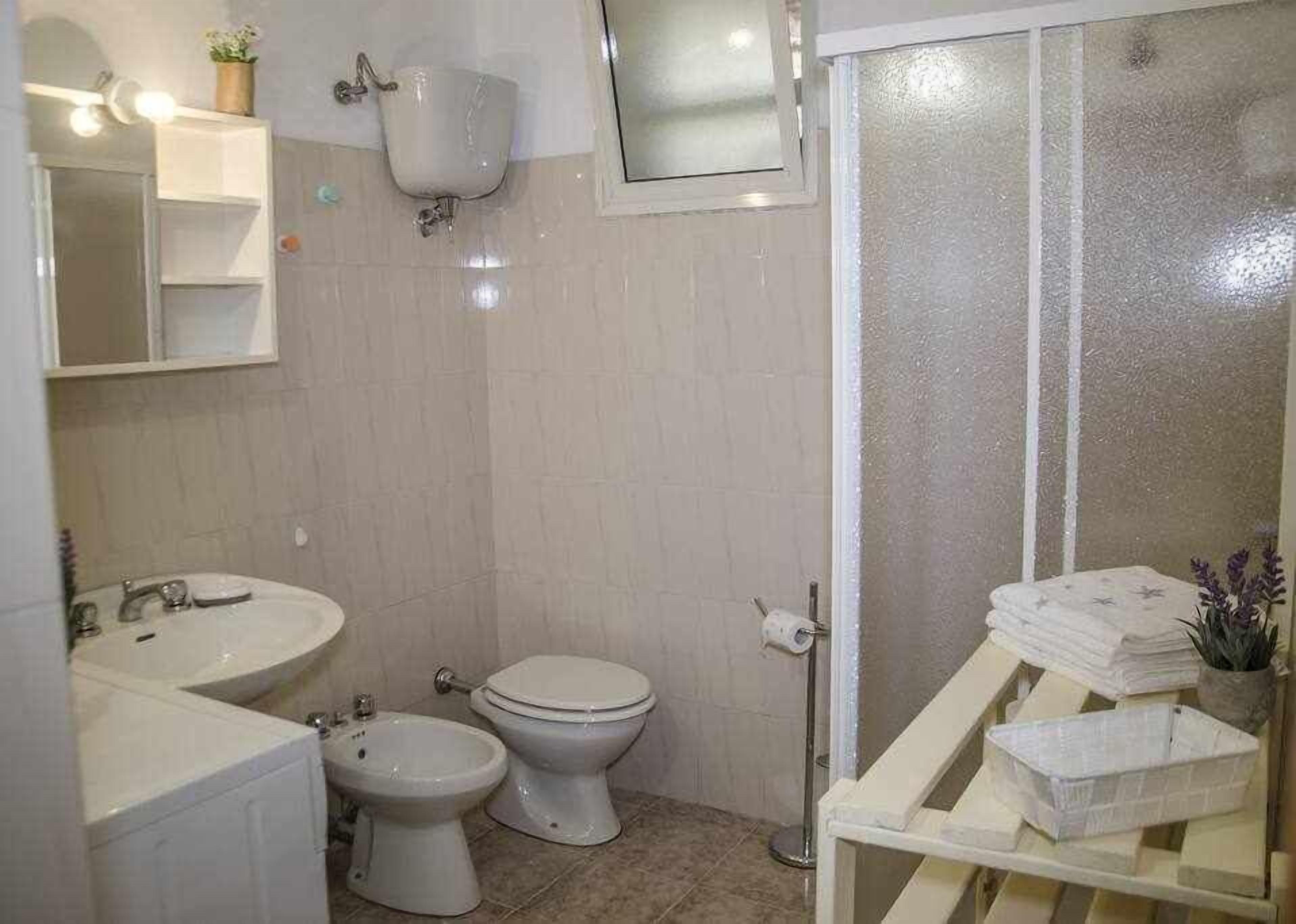 Une salle de bain équipée d’un lavabo, d’un bidet, de toilettes et d’un espace douche.