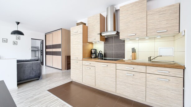 Una cocina moderna con armarios de madera, estufa integrada y cafetera.