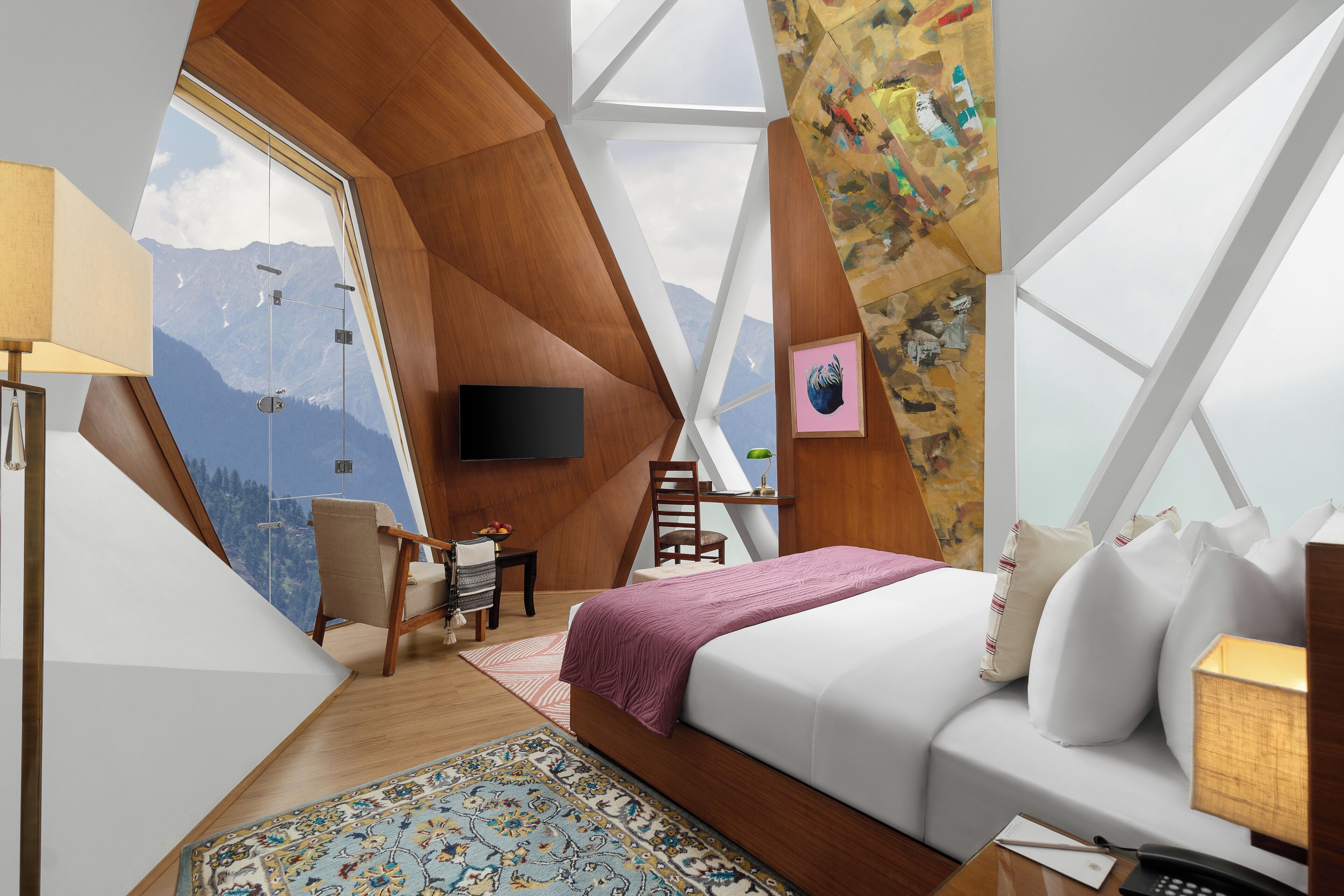A bedroom with a large window, a bed, a desk, and a chair.