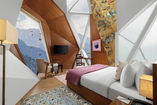 A bedroom with a large window, a bed, a desk, and a chair. - Tree of Life Eila Art Hotel (Kullu)