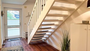 A staircase with white railings leading to a landing. - Vacation village house 63b (Ostseebad Boltenhagen)