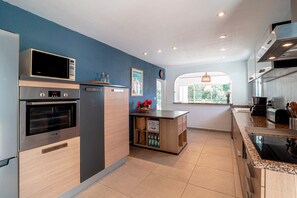 Una cocina moderna con electrodomésticos de acero inoxidable, una isla de madera y vistas al exterior.