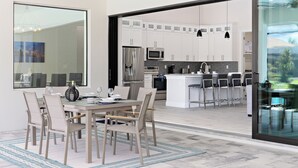 A modern kitchen with white cabinets, stainless steel appliances, and a bar area with stools.