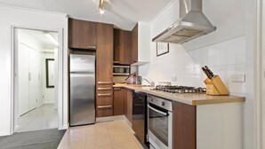 Eine moderne Küche mit Edelstahlgeräten, Holzschränken und einem Gasherd.