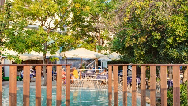 A pool area with wooden railings, umbrellas, and tables. - Hotel Eritrea (Cesenatico)
