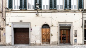 Ein Gebäude mit einer großen Holztür, einer kleineren Tür mit Fenster und einer Garagentür.