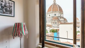 Ein Zimmer mit Fensterblick auf ein historisches Gebäude mit einer Kuppel.