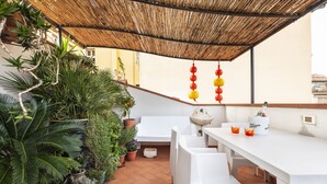 A patio with a white table, potted plants, and a bamboo ceiling. - Matteotti Apartment - Two Bedroom Apartment, Sleeps 6 (Firenze)