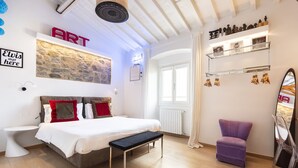 A bedroom with a bed, bench, and a purple chair. - Matteotti Apartment - Two Bedroom Apartment, Sleeps 6 (Firenze)
