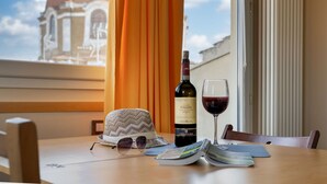 Een tafel met een fles Chianti-wijn, een wijnglas, een hoed en een tijdschrift.