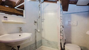 A bathroom with a sink, shower, and toilet.