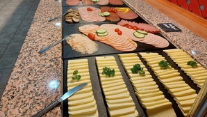 A buffet with various food items including meats, cheeses, and vegetables. - Sporthotel Neuruppin (Neuruppin)