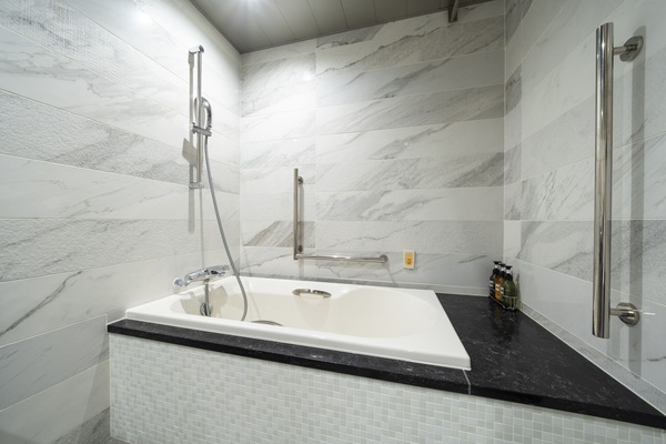 Habitación Deluxe con 2 camas individuales, para no fumadores (Universal) | Baño | Tina con regadera, secadora de cabello, pantuflas, toallas