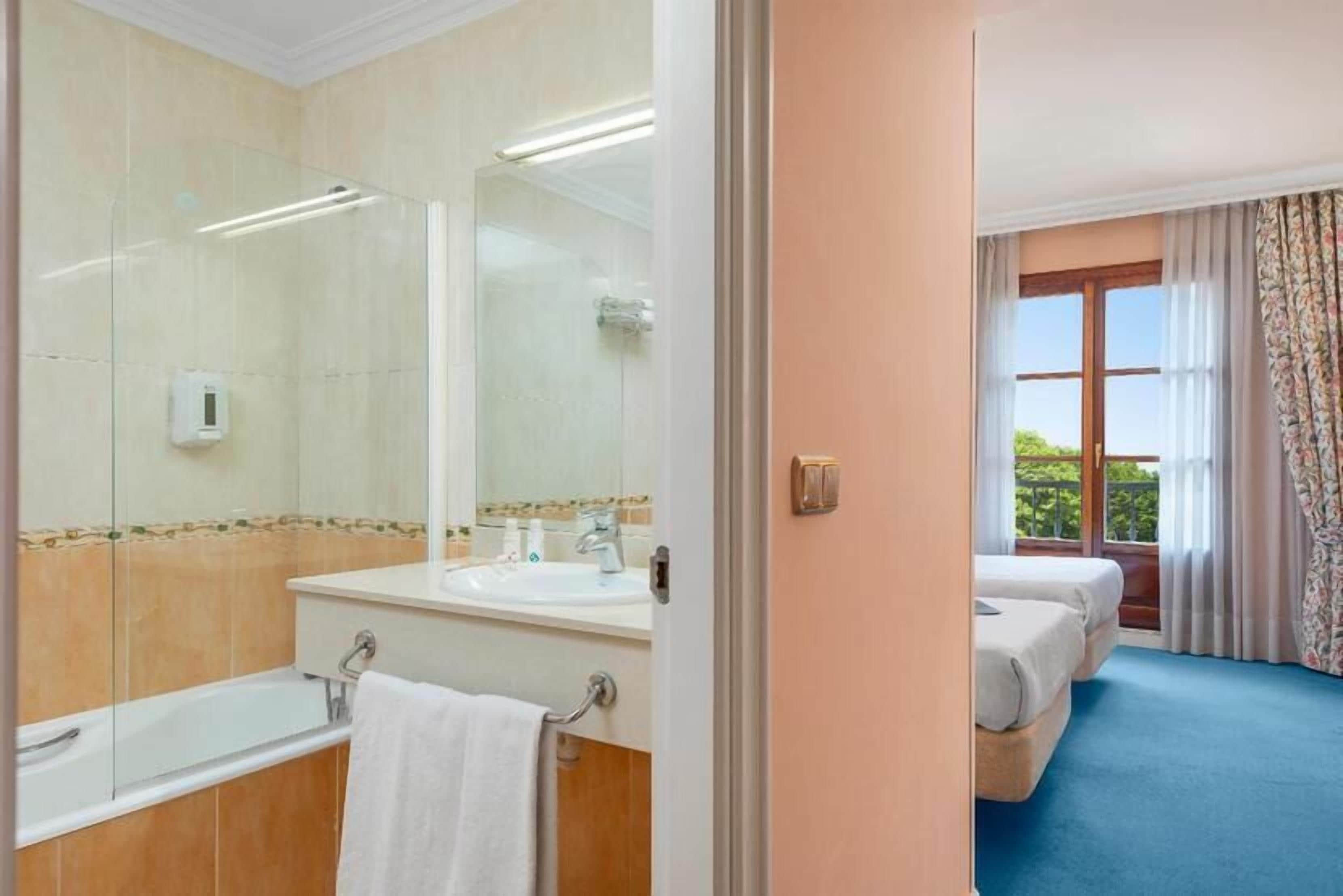 standard twin room | bathroom | combined shower/bathtub, hair dryer, towels, soap