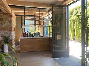 Una cocina moderna con una isla grande, vigas de madera y ventanas amplias.