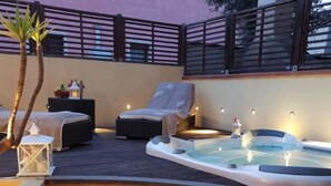 A hot tub on a wooden deck with steps leading up to it, a lounge chair, and a small table with a lantern. - Holiday Apartment 'Luxury Guesthouse Pula' with Garden, 2 Terraces & Wi-Fi (Pula)
