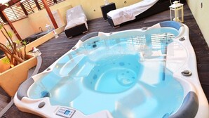 A hot tub with a control panel, surrounded by lounge chairs and a wooden deck. - Holiday Apartment 'Luxury Guesthouse Pula' with Garden, 2 Terraces & Wi-Fi (Pula)