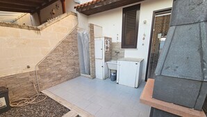 A small outdoor kitchen area with a sink, a white refrigerator, and a stone wall. - Pet-Friendly 'Villa Andrea' with Sea View, Garden & Wi-Fi (Manduria)