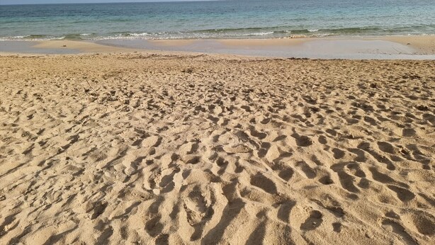 A sandy beach with footprints leading to the water. - Pet-Friendly 'Villa Andrea' with Sea View, Garden & Wi-Fi (Manduria)