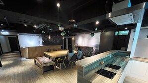 A modern kitchen with a wooden countertop, a built-in stove, and pendant lighting. - Formosa101 Taipei Main Branch (Taipei)