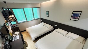 A hotel room with two single beds, a desk with a laptop, a chair, and a window with a view. - Formosa101 Taipei Main Branch (Taipei)