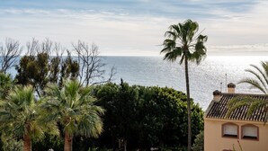A coastal view with palm trees and a building with a tiled roof. - Apartment 'Sea Views Torre Oceano 7' with Shared Pool & Wi-Fi (Mijas costa)